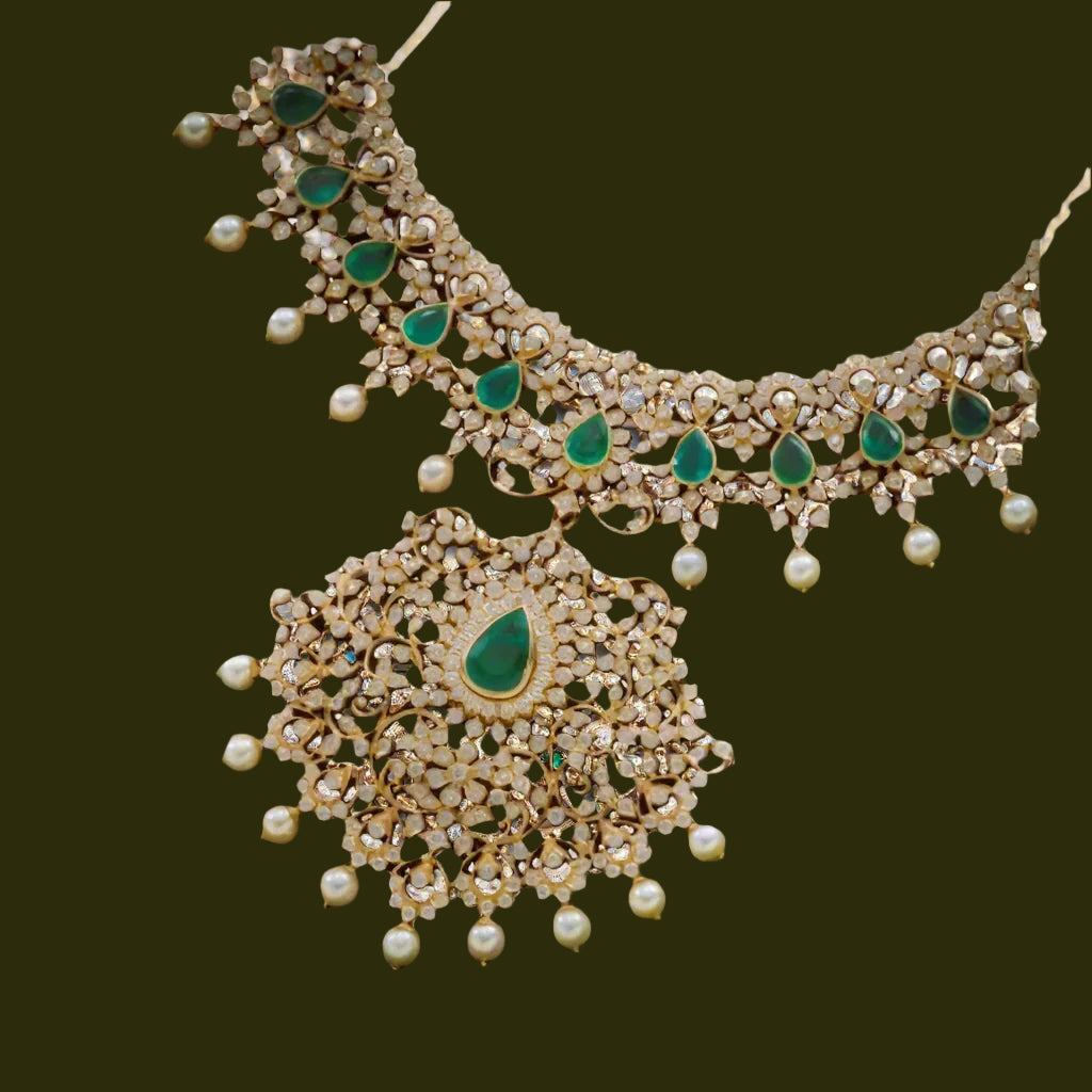 Ornate necklace with green and pearl details on a light background